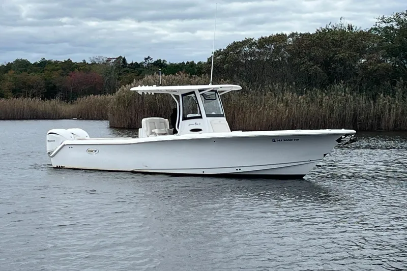 The Image of 2024 Sea Hunt Gamefish 30 Forward Seating boat on calm water, surrounded by reeds. - 0