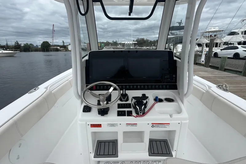 Slide: The Image of 2024 Sea Hunt Gamefish 30 boat console with advanced navigation system and steering wheel. - 15