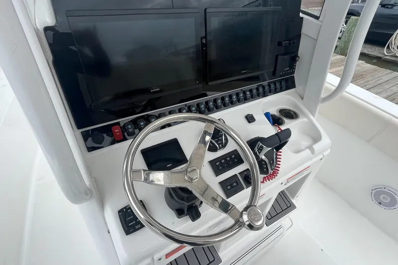 Slide: The Image of 2024 Sea Hunt Gamefish 30 helm with dual displays and modern controls. - 16