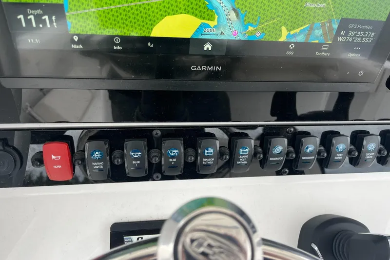 Slide: The Image of 2024 Sea Hunt Gamefish 30 dashboard with Garmin display and control switches. - 18