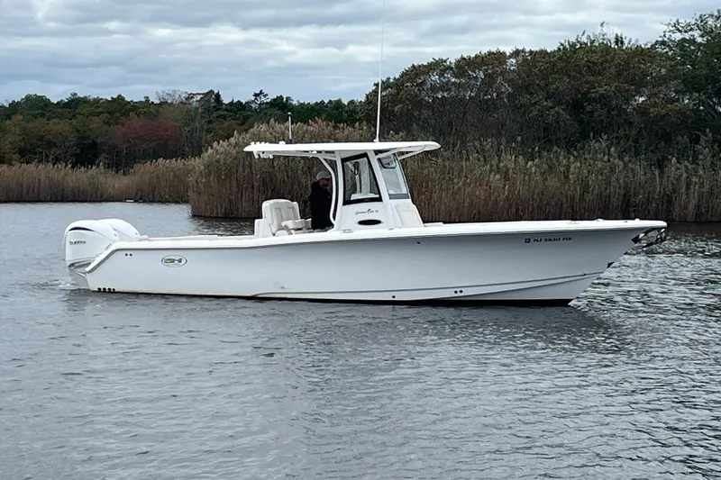 Slide: The Image of 2024 Sea Hunt Gamefish 30 Forward Seating boat on calm water, side view. - 3
