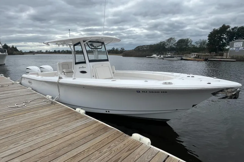 Slide: The Image of 2024 Sea Hunt Gamefish 30 Forward Seating boat docked on a cloudy day. - 9