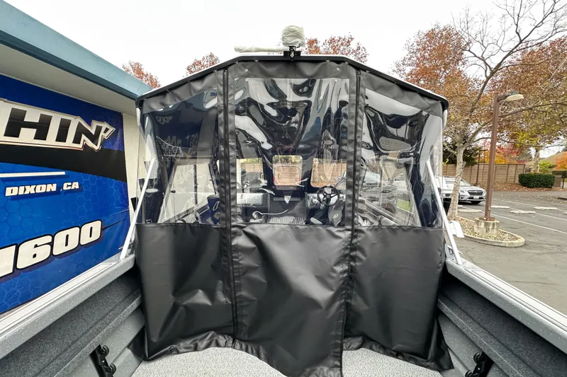 Slide: The Image of 2026 Lund 210 Heavy Gauge boat with protective cover in a parking lot. - 15