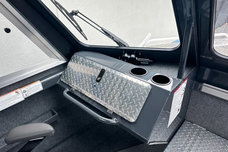 Slide: The Image of Interior of 2026 Lund 210 Heavy Gauge boat with diamond plate storage and cup holders. - 25