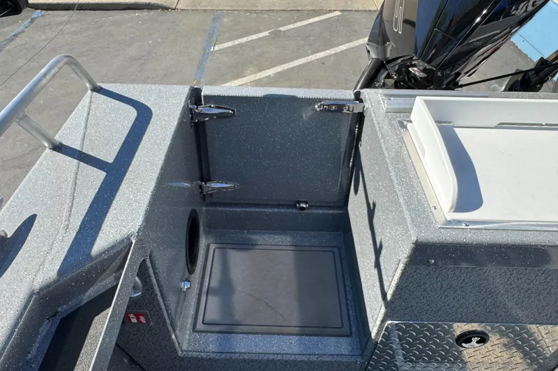 Slide: The Image of 2026 Lund 210 Heavy Gauge boat interior with storage compartment and motor. - 38