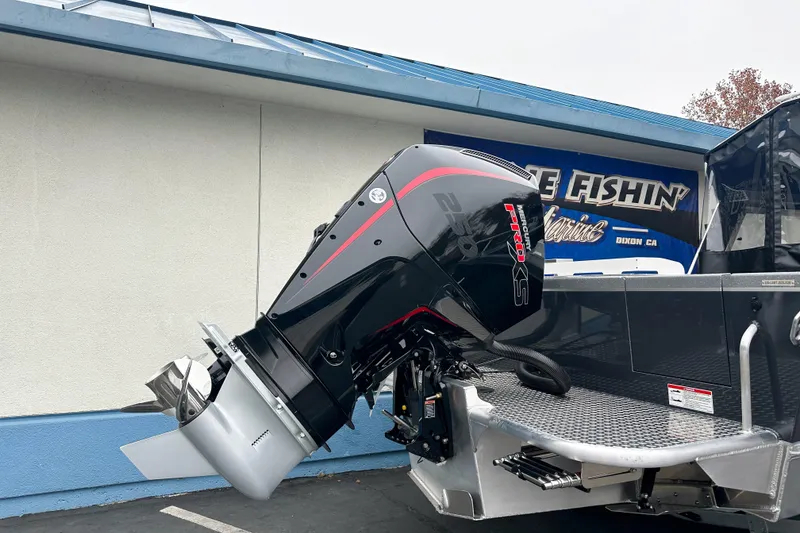 Slide: The Image of 2026 Lund 210 Heavy Gauge boat with powerful outboard motor displayed outdoors. - 4