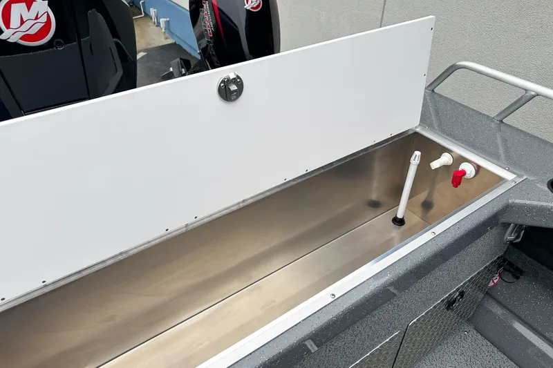 Slide: The Image of 2026 Lund 210 Heavy Gauge boat interior with storage compartment and plumbing fixtures. - 8