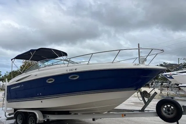 The Image of 2006 Monterey 250 Cruiser boat on trailer under cloudy sky. - 0