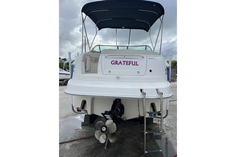 Slide: The Image of 2006 Monterey 250 Cruiser boat with "Grateful" name, docked under cloudy skies. - 1