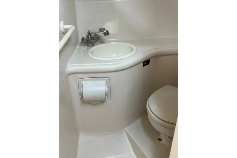 Slide: The Image of Compact bathroom in 2006 Monterey 250 Cruiser boat, featuring sink and toilet. - 13