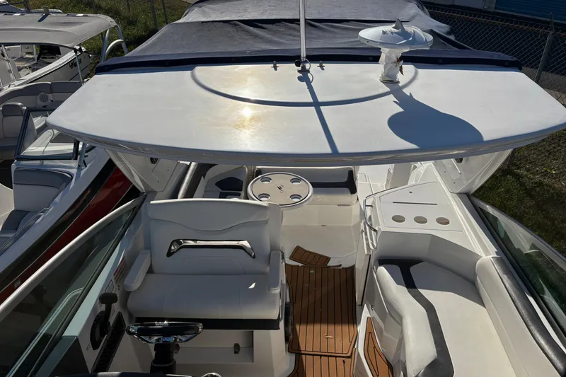 Slide: The Image of 2016 Monterey 295 Sport Yacht cockpit with white seating and wooden flooring. - 22