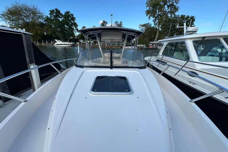 Slide: The Image of 1999 Intrepid 339 boat docked between other vessels on a calm waterway. - 11