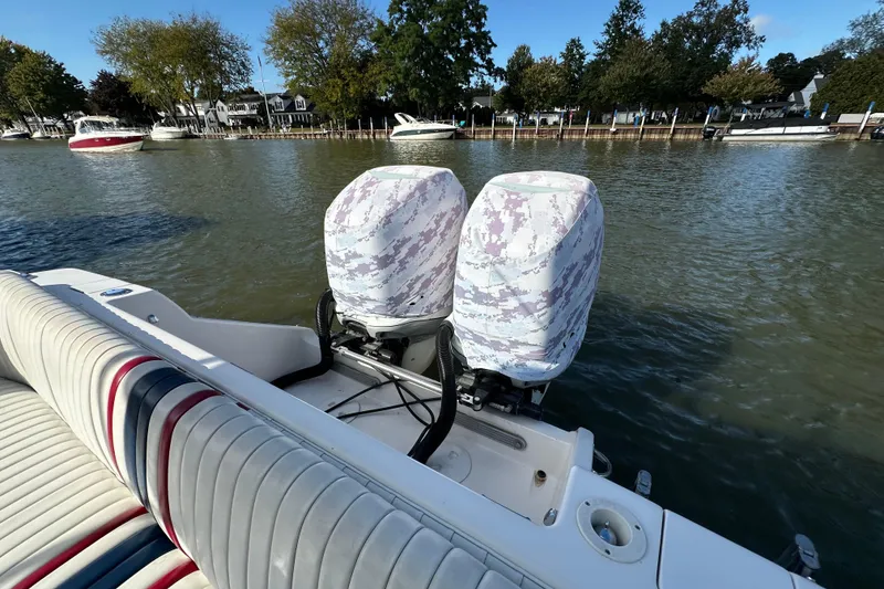 Slide: The Image of 1999 Intrepid 339 boat with camouflaged outboard motors on a calm lake. - 14