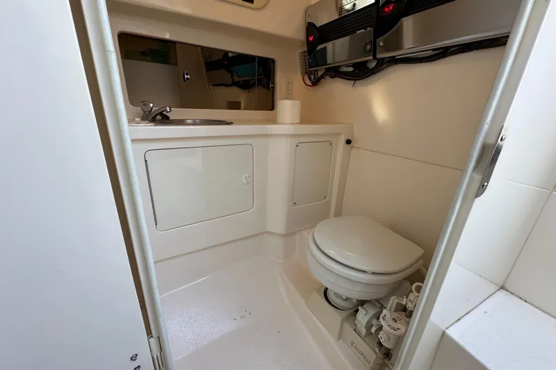 Slide: The Image of Open refrigerator inside a 1999 Intrepid 339 boat, showing empty shelves and compartments. - 19