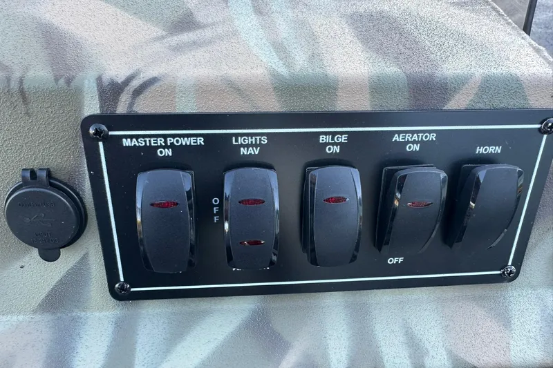 Slide: The Image of Control panel of 2026 Lowe Roughneck 2070SC boat with switches for power, lights, bilge, aerator, horn. - 15