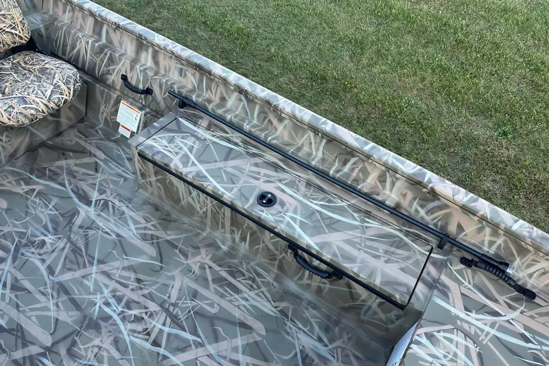 Slide: The Image of 2026 Lowe Roughneck 2070SC boat interior with camouflage design and seating. - 18