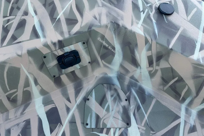 Slide: The Image of Camouflage pattern on 2026 Lowe Roughneck 2070SC boat surface with visible hardware. - 22