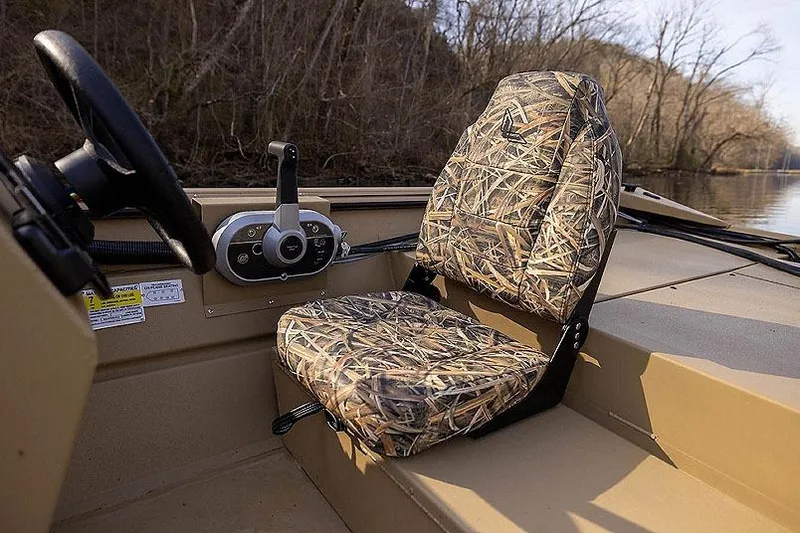 Slide: The Image of 2026 Lowe Roughneck 2070SC boat on trailer, camouflage design, parked outside a building. - 4