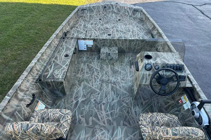 Slide: The Image of 2026 Lowe Roughneck 2070SC boat with camouflage interior, steering console, and seating. - 8