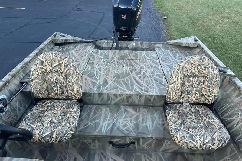 Slide: The Image of 2026 Lowe Roughneck 2070SC boat with camouflage seating and outboard motor. - 9