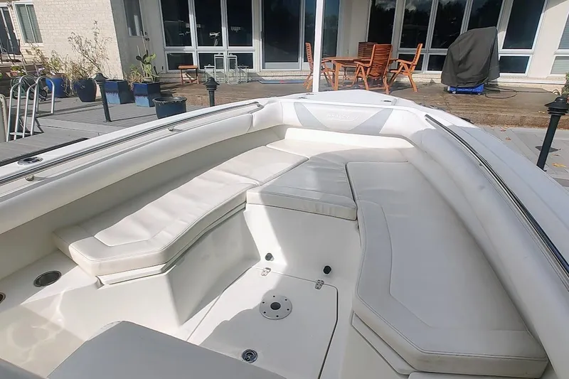 Slide: The Image of 2012 Boston Whaler 280 Outrage boat interior with white cushioned seating. - 16