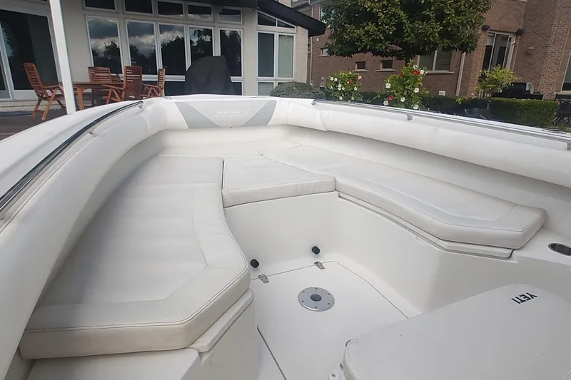 Slide: The Image of 2012 Boston Whaler 280 Outrage boat interior with cushioned seating and outdoor setting. - 17