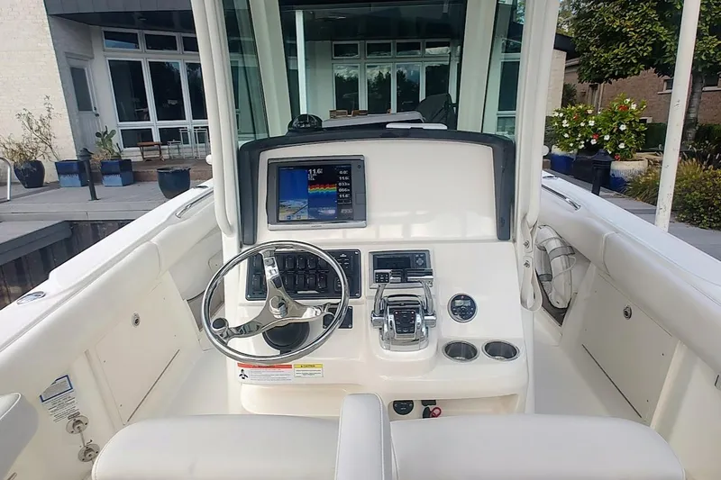Slide: The Image of 2012 Boston Whaler 280 Outrage helm with steering wheel and navigation display. - 26