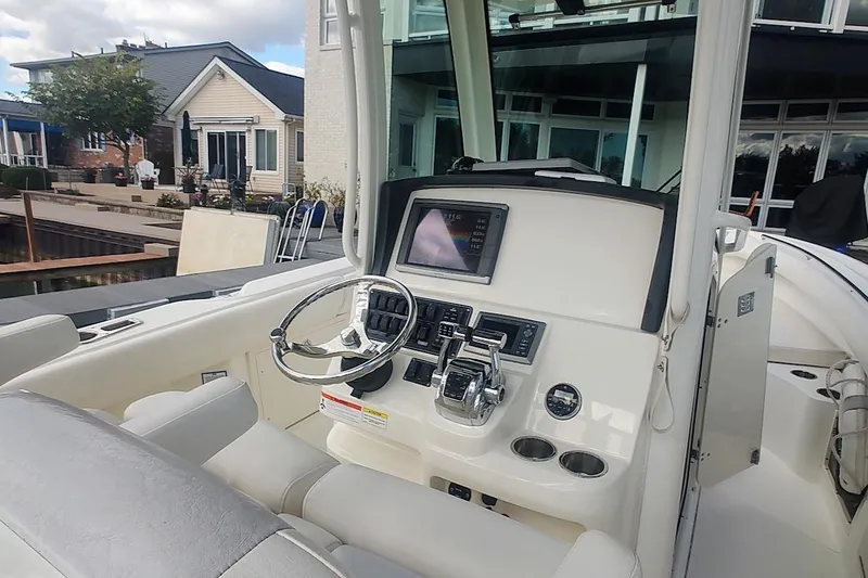 Slide: The Image of 2012 Boston Whaler 280 Outrage boat helm with steering wheel and control panel. - 27