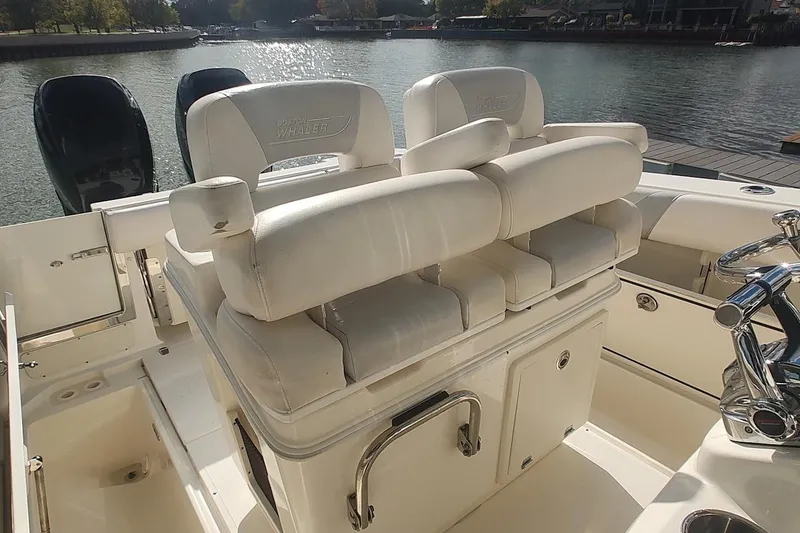 Slide: The Image of 2012 Boston Whaler 280 Outrage boat interior with white seating and dual engines. - 34