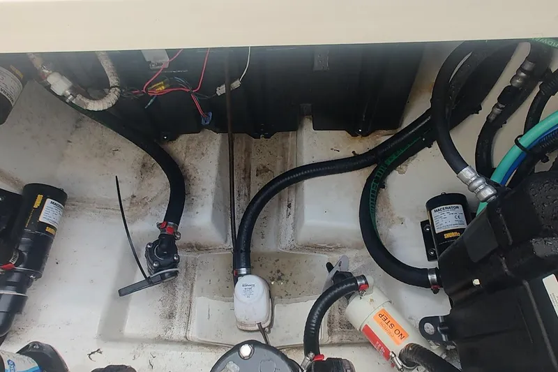 Slide: The Image of 2012 Boston Whaler 280 Outrage engine compartment with wiring and hoses visible. - 51