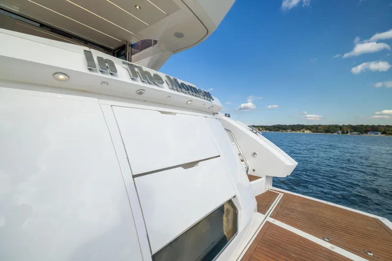 Slide: The Image of 2018 Sunseeker Manhattan 52 yacht on water, featuring sleek design and wooden deck. - 12