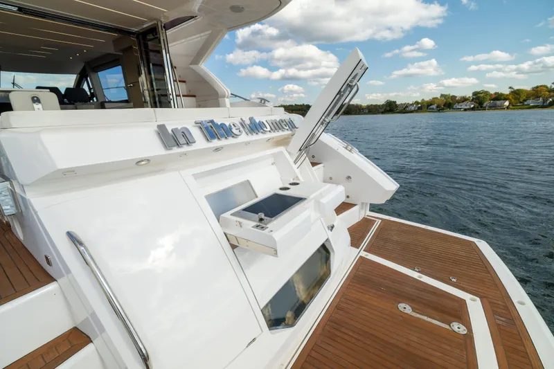 Slide: The Image of 2018 Sunseeker Manhattan 52 yacht on water, featuring sleek design and spacious deck. - 13