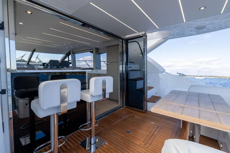 Slide: The Image of Luxurious 2018 Sunseeker Manhattan 52 yacht interior with modern seating and wooden deck. - 20