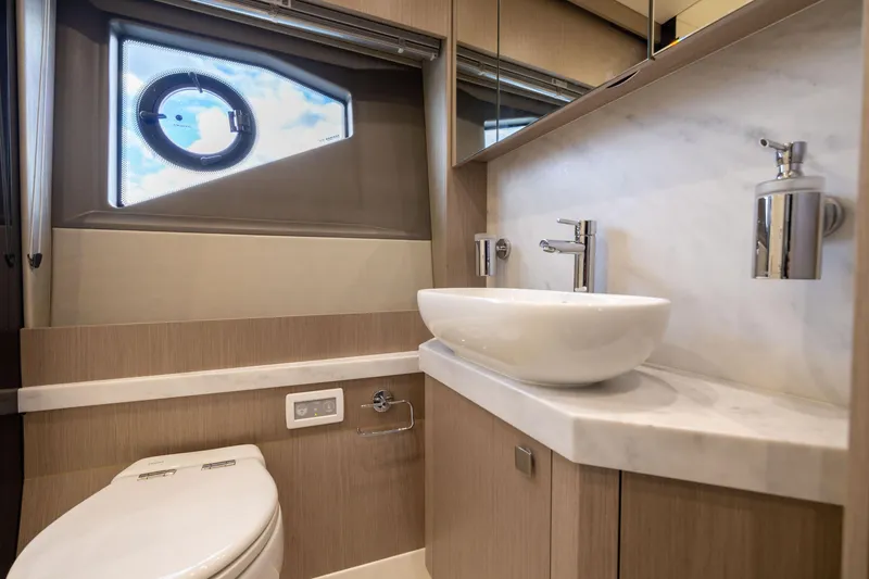 Slide: The Image of Luxurious bathroom in 2018 Sunseeker Manhattan 52 yacht with modern fixtures and porthole window. - 52