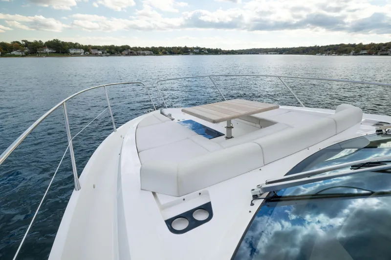 Slide: The Image of 2018 Sunseeker Manhattan 52 yacht with luxurious deck seating on calm waters. - 61