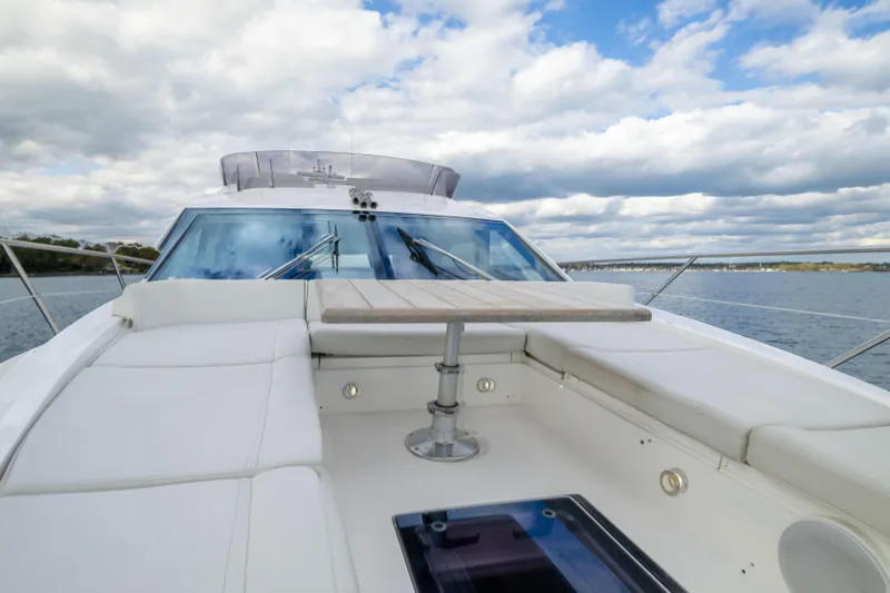 Slide: The Image of 2018 Sunseeker Manhattan 52 yacht deck with seating and table, under a cloudy sky. - 63