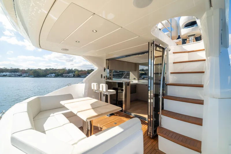 Slide: The Image of Luxurious 2018 Sunseeker Manhattan 52 yacht with elegant outdoor seating and scenic water view. - 65