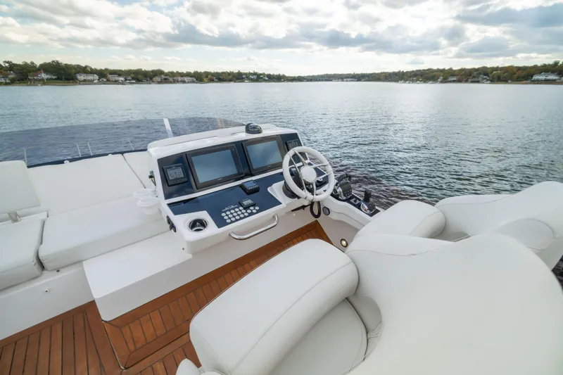 Slide: The Image of 2018 Sunseeker Manhattan 52 yacht helm with dual screens and luxurious seating on open water. - 68