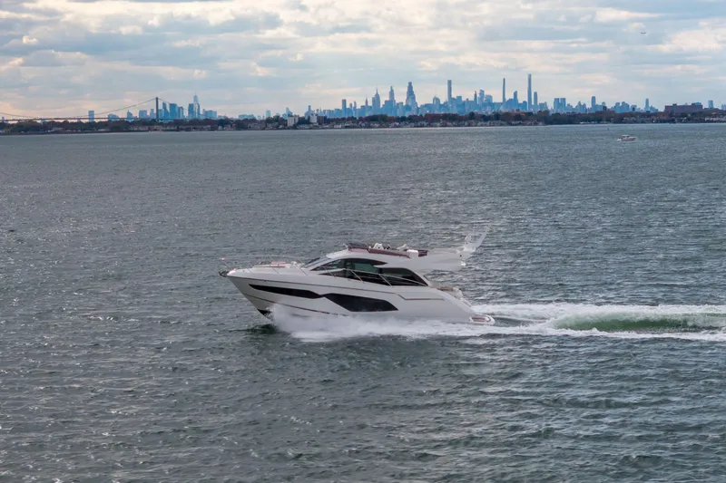 Slide: The Image of 2018 Sunseeker Manhattan 52 yacht cruising with city skyline in the background. - 85