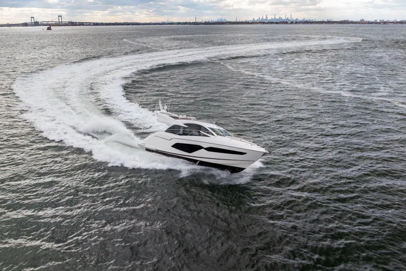 Slide: The Image of 2018 Sunseeker Manhattan 52 yacht cruising on open water, creating a dynamic wake. - 88