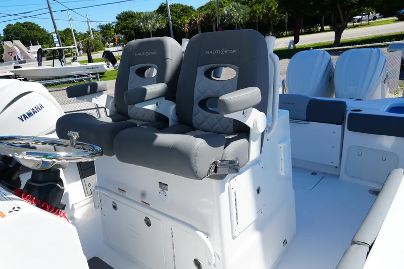 Slide: The Image of 2025 NauticStar 292 Legacy boat with dual captain's chairs and Yamaha engine. - 16