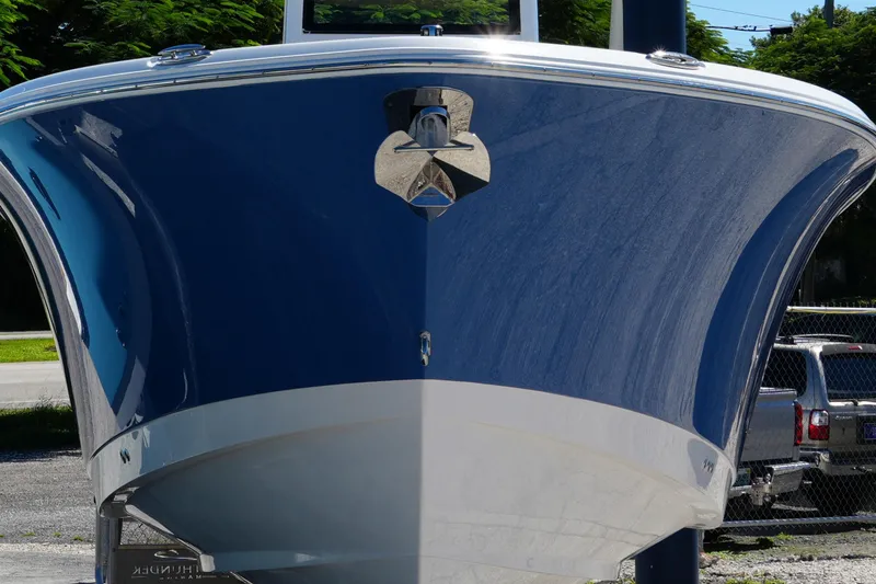 Slide: The Image of 2025 NauticStar 292 Legacy boat, blue hull, front view, parked outdoors. - 3