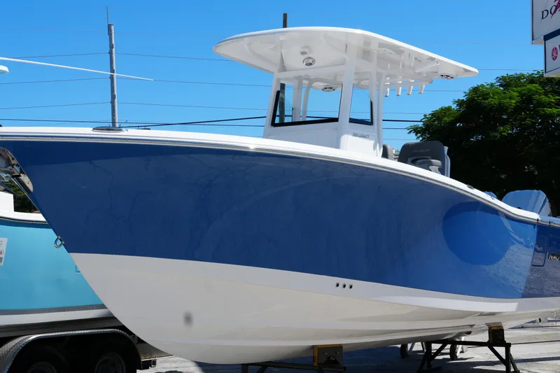 Slide: The Image of 2025 NauticStar 292 Legacy boat with blue hull, displayed outdoors. - 4