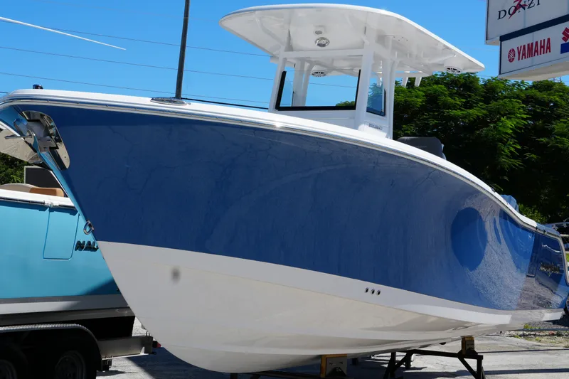 Slide: The Image of 2025 NauticStar 292 Legacy boat with sleek blue and white design on display. - 5