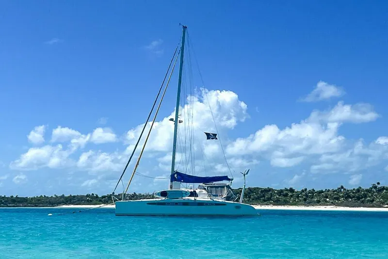 Slide: The Image of Sailboat Dolphin 460, 2006 model, anchored in clear turquoise waters under a blue sky. - 1