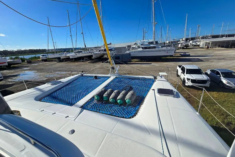 Slide: The Image of 2006 Dolphin 460 catamaran on land, surrounded by parked cars and other boats. - 13