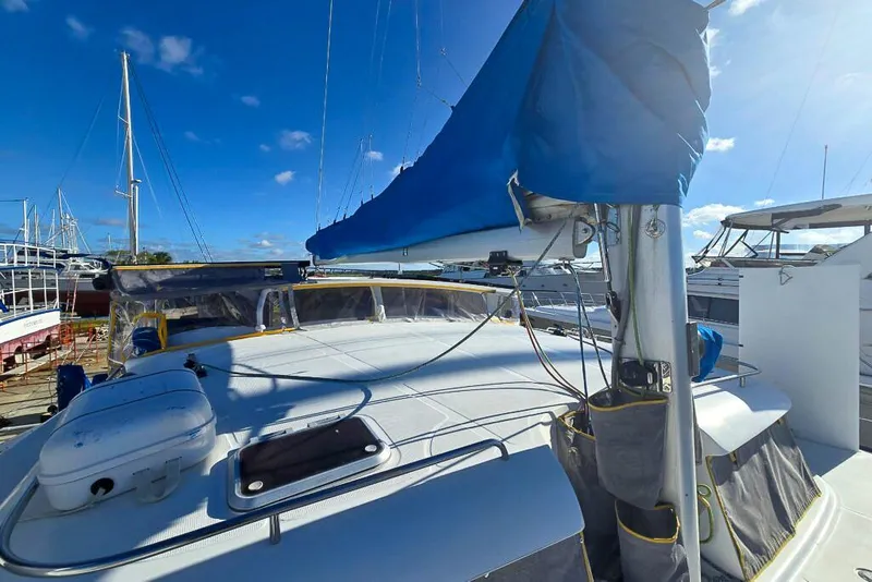 Slide: The Image of Sailboat deck view of 2006 Dolphin 460, featuring blue sail cover and clear sky. - 15