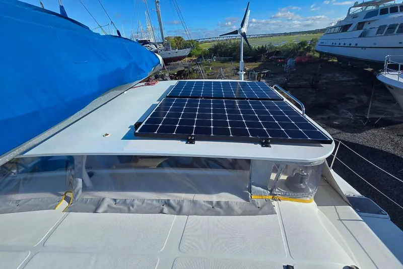 Slide: The Image of Sailboat with solar panels and wind turbine, Dolphin 460 model, 2006, docked under blue sky. - 17