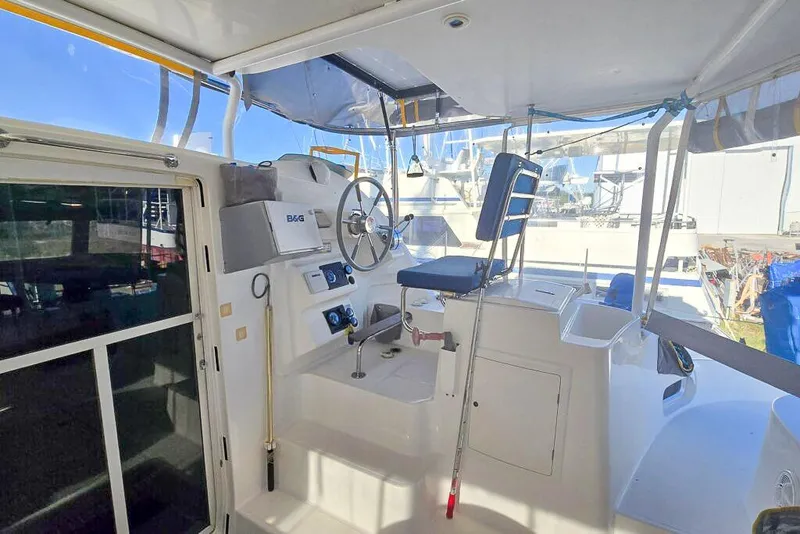Slide: The Image of Helm station of 2006 Dolphin 460 catamaran with steering wheel and navigation equipment. - 24