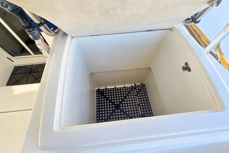Slide: The Image of Open storage compartment on a 2006 Dolphin 460 boat, featuring a grid base. - 28